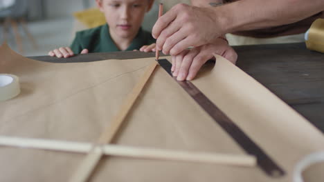 father and son making a kite together