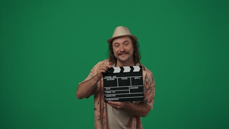 man holding clapperboard on green screen