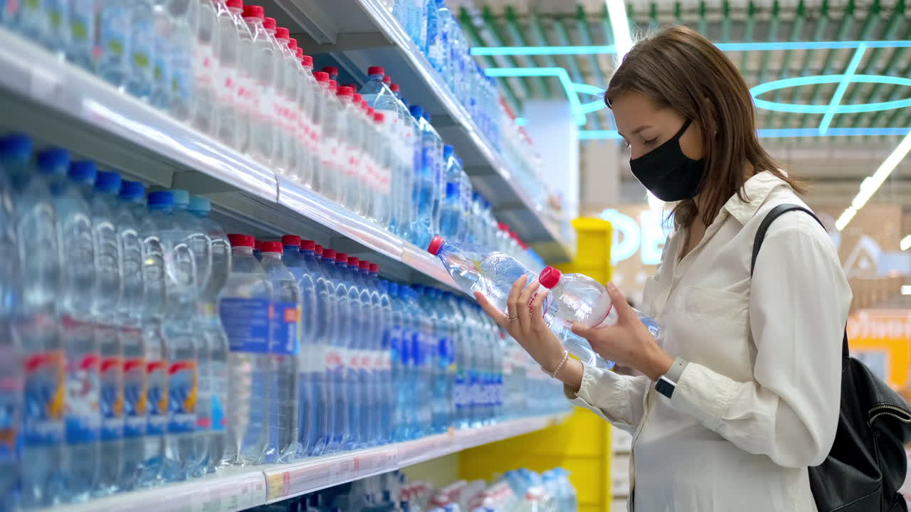 슈퍼마켓 에서 물 병 을 구입 하는 여자