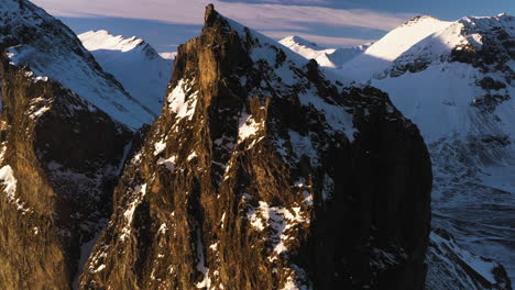 flying around a rocky cliff full of birds, dramatic winter evening in iceland - aerial view