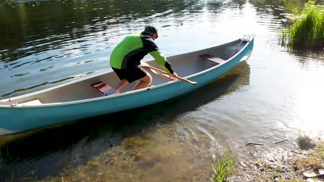 man getting into canoe on lake