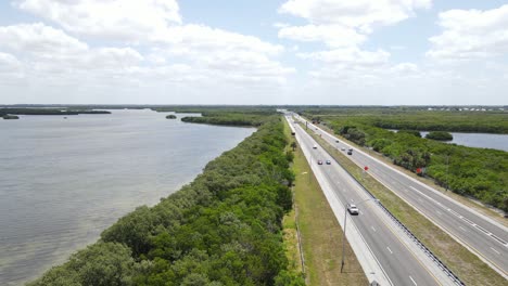 backward-aerial-down-the-Sunshine-Skyway-Tollway-outside-Tampa,-Florida-going-to-St