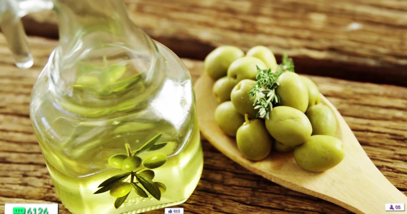 Bottiglia di vetro di olio d'oliva in piedi accanto a un cucchiaio di legno che contiene olive e icone di social media fluttuanti