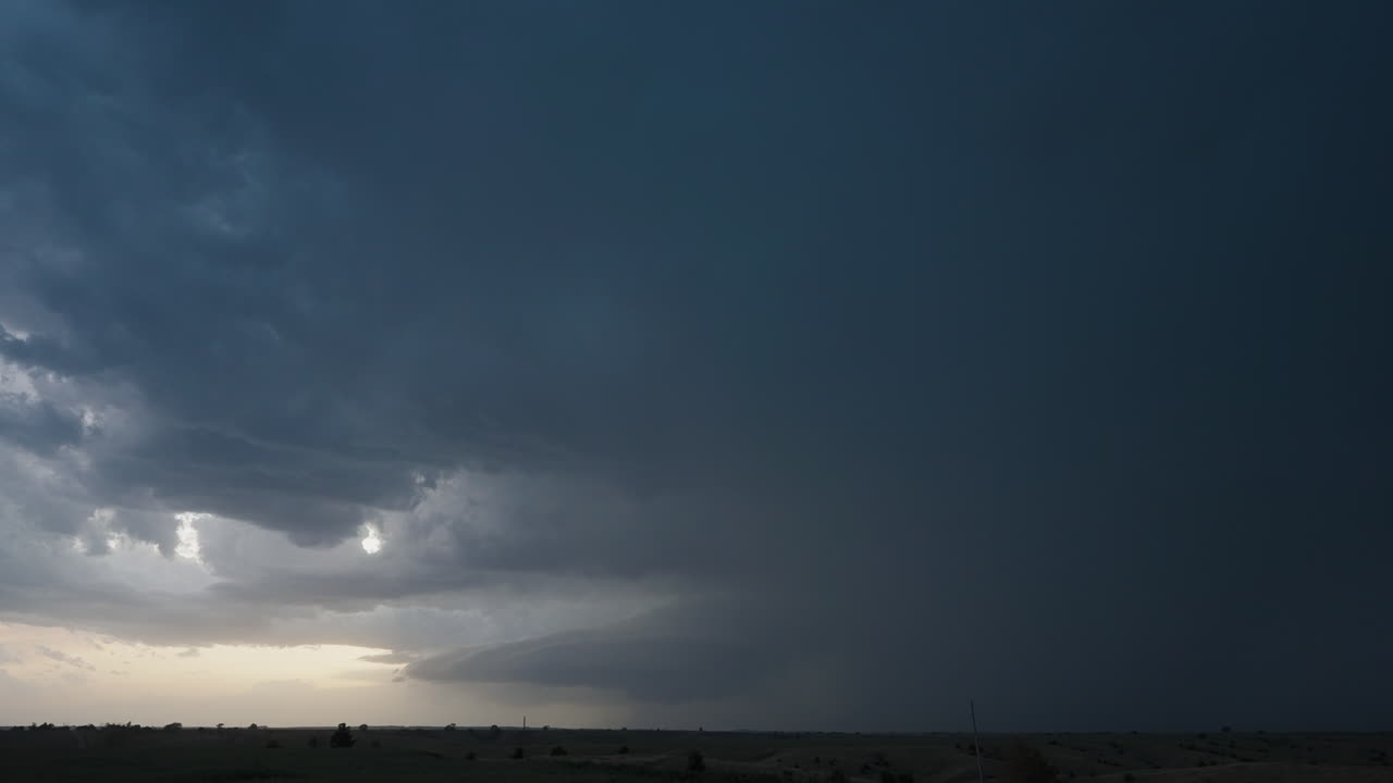 Dramatic Storm Clouds with Lightning Over Rural Landscape at Dusk