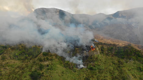 aerial view of smoke rising into the sky as a wildfire burns on a mountainside