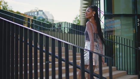 stylish brunette stepping stairs alone. trendy  braids fashionista walking