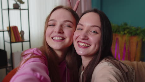 two women friends siblings bloggers at home, laughing, spend leisure time taking selfie pictures