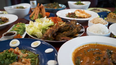 Ein-Sehr-Voller-Tisch-Mit-Verschiedenen-Farbenfrohen-Thailändischen-Gerichten,-Asiatisches-Essen-Im-Restaurant,-Slider-4k