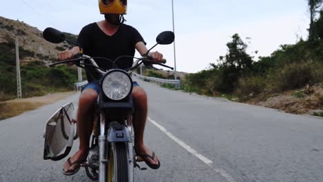 man rides motorcycle with kiteboard and kite surfing gear, surf trip in vietnam