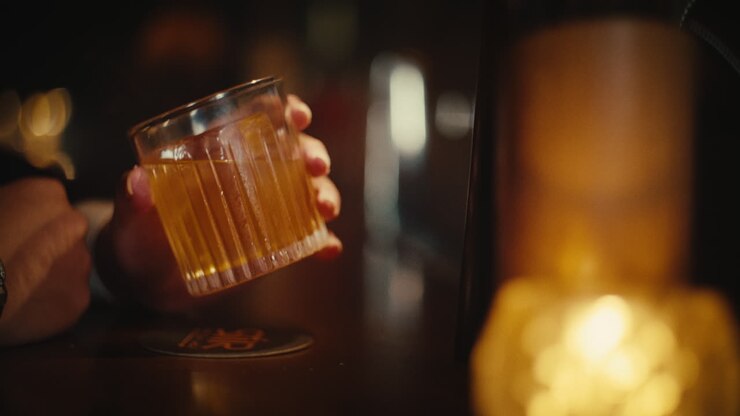 Person holding a cocktail at a bar