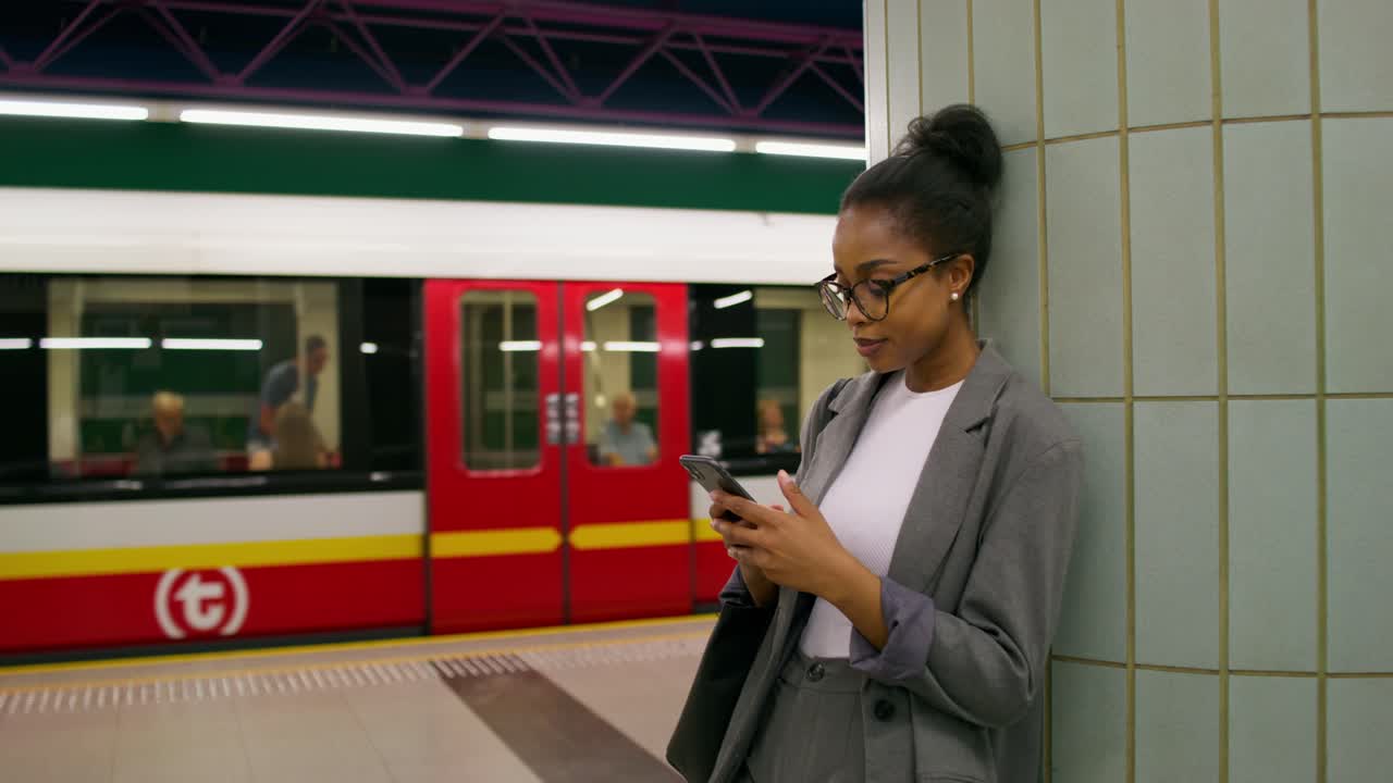 mujer usando el teléfono en una estación de metro