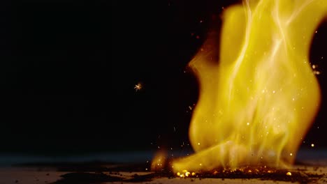 sparks are ejected away from a pile of burning powder that is burning vigorously