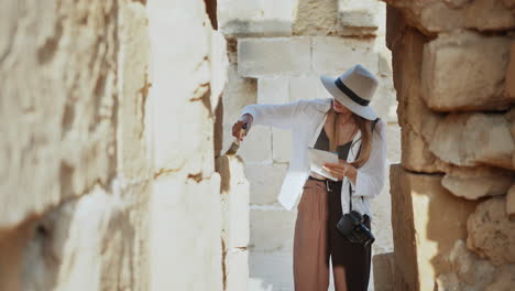 woman exploring and documenting ancient ruins