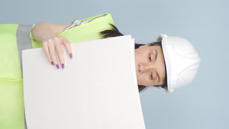 Vertical-video-of-The-engineer-examines-the-project-in-her-hands.