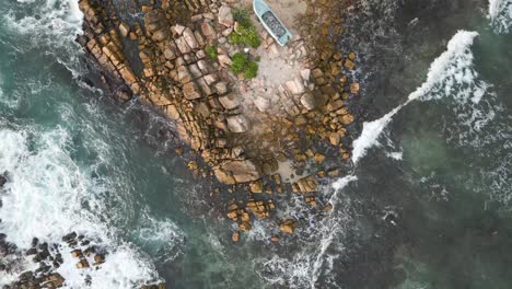 Aerial-top-shot-of-splashing-waves-at-a-rocky-cliff-near-Mirissa,-Sri-Lanka