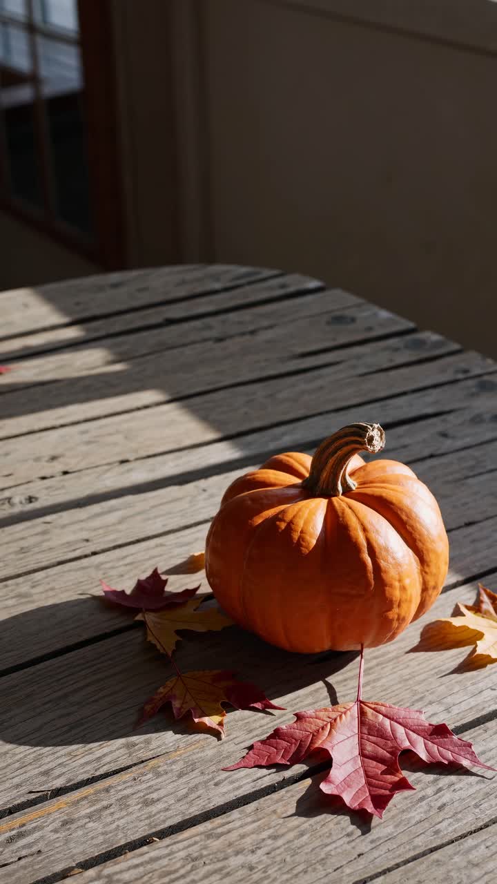 A rustic autumn scene with a pumpkin on a wooden table, captured from a high angle