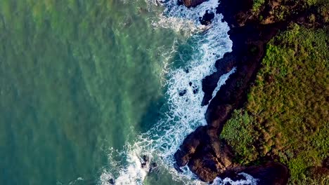 Toma-Aérea-Girando-Sobre-Las-Olas-Iluminadas-Por-El-Sol-Rompiendo-En-Los-Acantilados-Rocosos-De-California