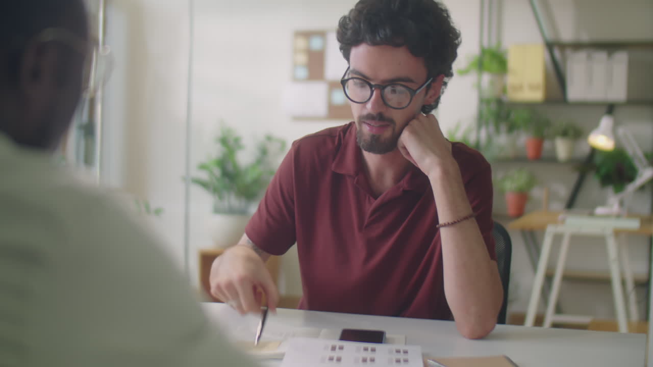 Man Discussing Business Papers with Coworker in Office