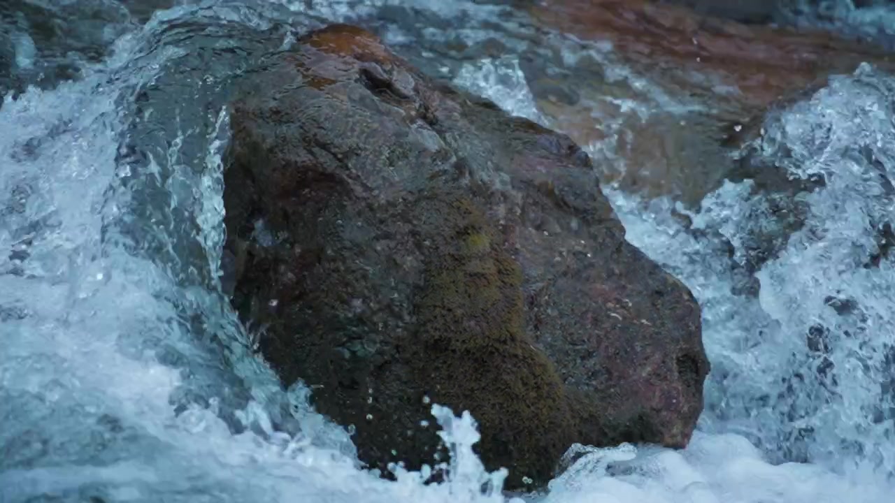 Corso d'acqua che scorre intorno a un grande masso