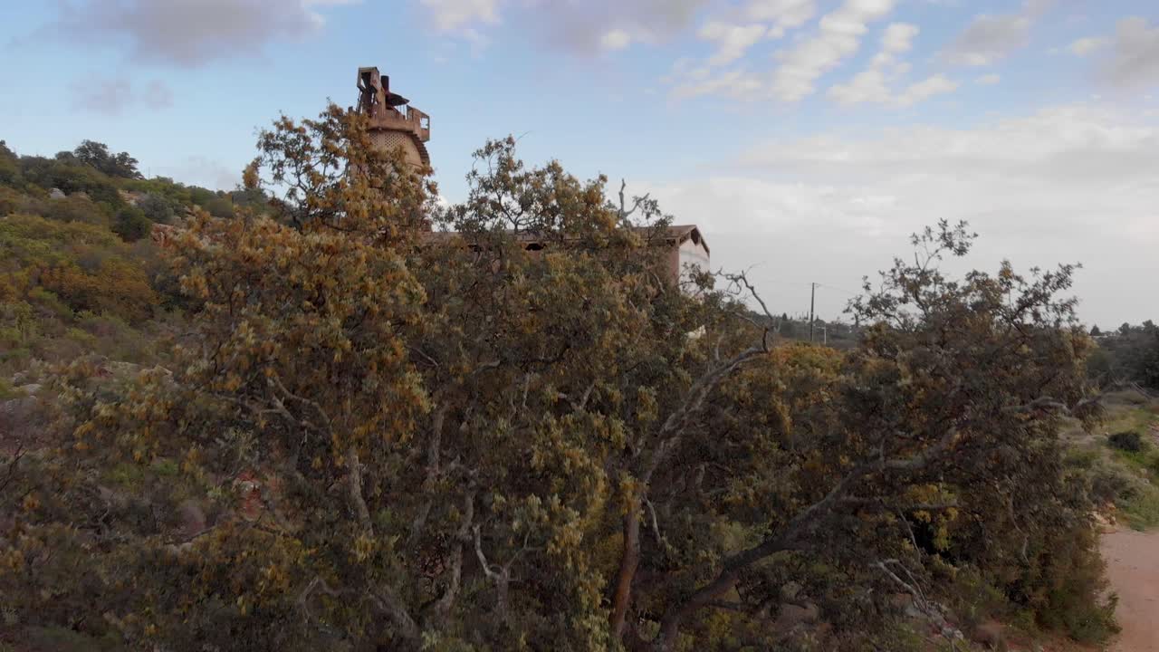 antigua fábrica de cal viva abandonada con graffiti, el dron se levanta detrás del árbol
