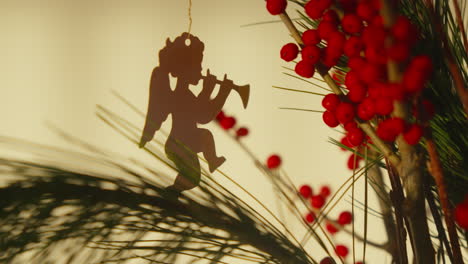 christmas angel ornament and festive berries in a warm holiday setting