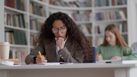 student coughing while studying in library