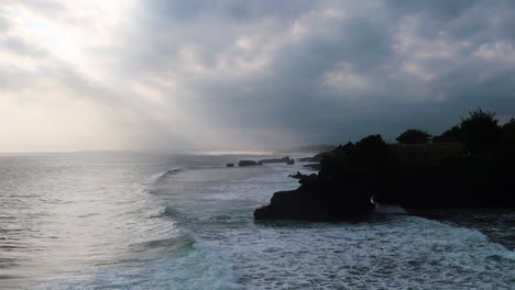 waves crashing against the shore in bali