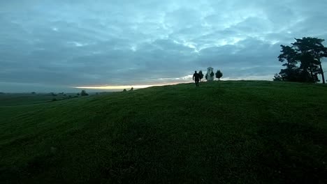 a slow drone shot following a teenager running up the hill during sunrise