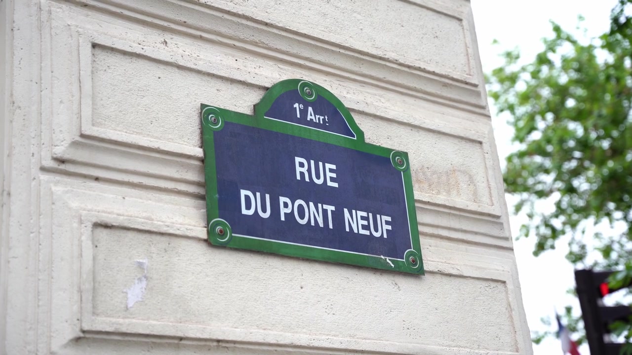 Primo piano di un'iconica insegna stradale in metallo blu e verde per Rue du Pont Neuf nel 1° arrondissement di Parigi, Francia. Evidenzia il design urbano e la tipografia tradizionali parigini.