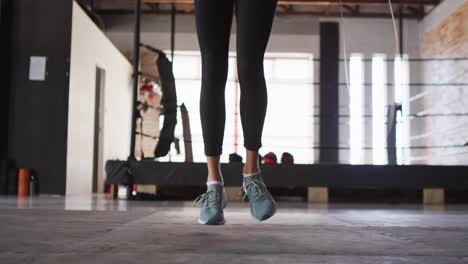 Video-of-legs-of-fit-caucasian-woman-jumping-on-jumping-rope-at-gym