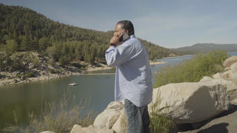 Man-on-cell-phone-with-Lake-in-the-background