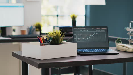 business forecasting graphs showing profits on laptop in empty office