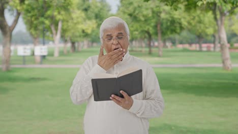 Sleepy-Indian-old-man-reading-a-book-in-park