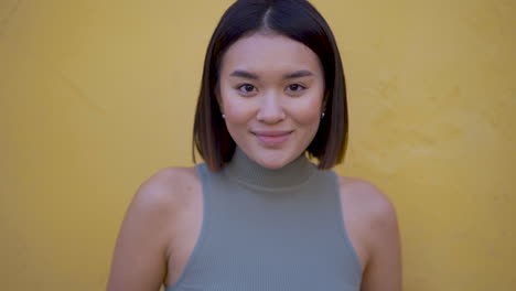 portrait of young pretty female looking at camera and smiling outdoors