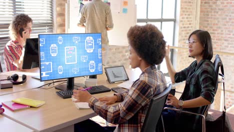 Diverse businesswomen using computer with data processing on screen in office