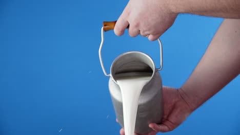 male hand poured milk from a can.