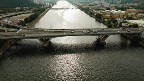 Cars-driving-on-highway-over-a-wide-waterway-bridge-in-HongKong,-China