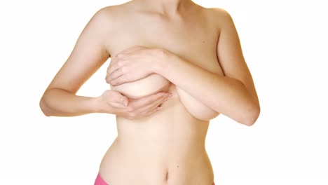 mujer joven en topless haciendo autoexamen de mama
