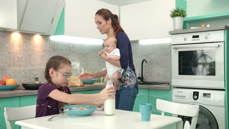 girl eating cereal breakfast with mother and baby boy. family breakfast time