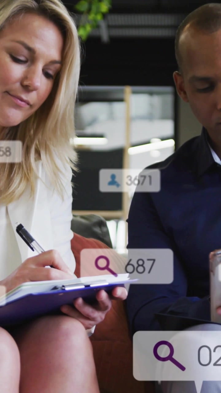 Video vertikal: Wanita kantor menulis catatan, overlay pencarian memperbarui data sementara pria memeriksa perangkat