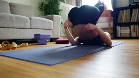 woman practicing yoga in living room