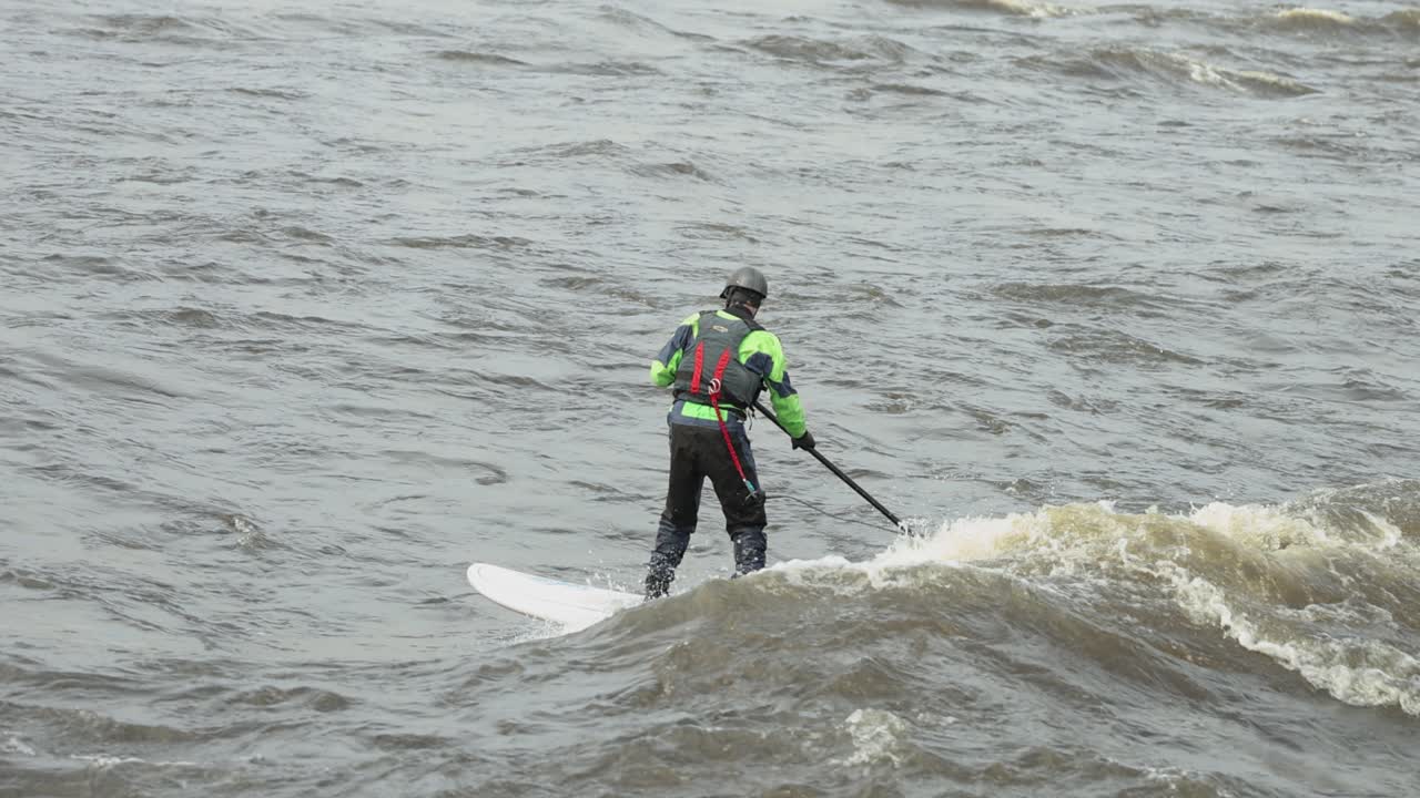 롱 보딩 서퍼는 베이트 섬의 강 급류에서 생성된 오타와 강에서 항적을 탄다