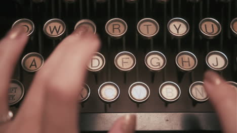 close up top down shot of hands typing on mechanical typewriter keys - dolly left to right