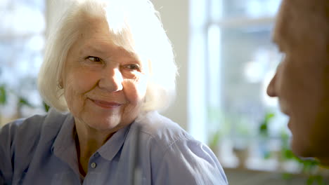 close-up view of a senior woman talking with her husband in a bar at sunset