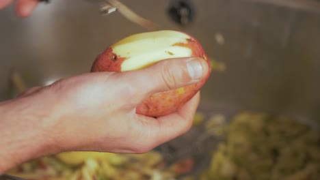 male hands peeling an irish rooster potato