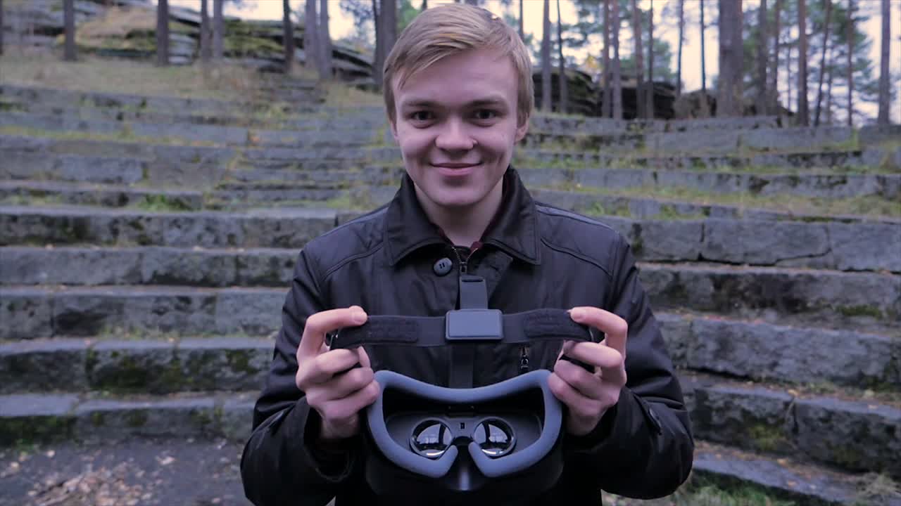 человек, держащий наушники на открытом воздухе