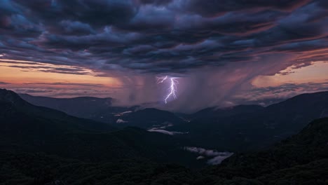 Aerial video captures a dramatic sunset over misty mountains, with vibrant clouds and deep valleys