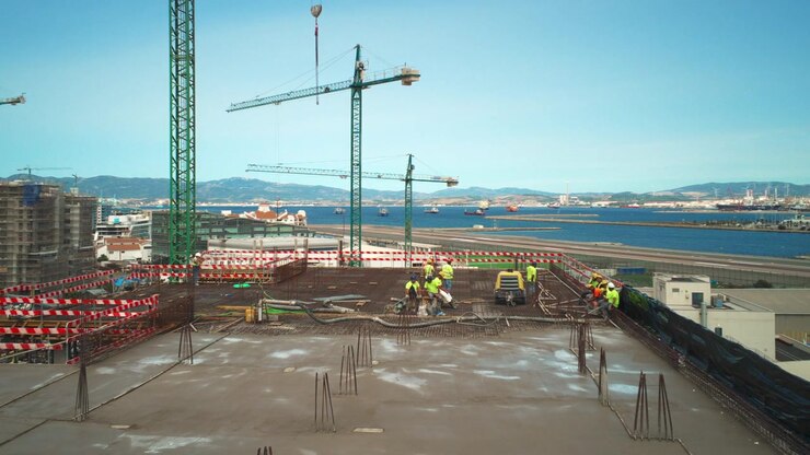 Construction worker team pouring concrete on rooftop slab