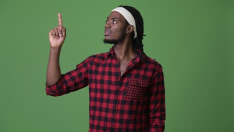young handsome african man with dreadlocks against green background