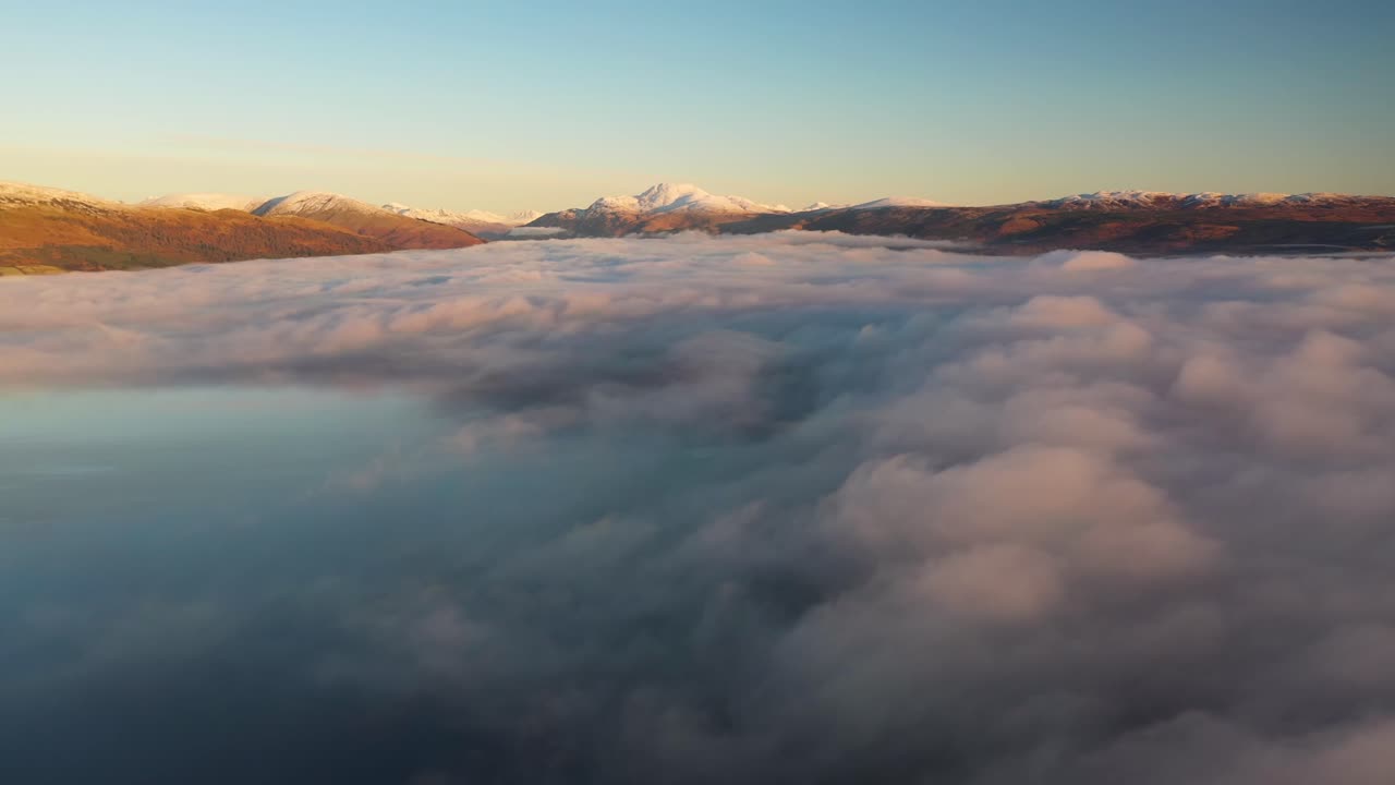 hermoso amanecer sobre loch lomond volando sobre las nubes con ben lomond en la distancia